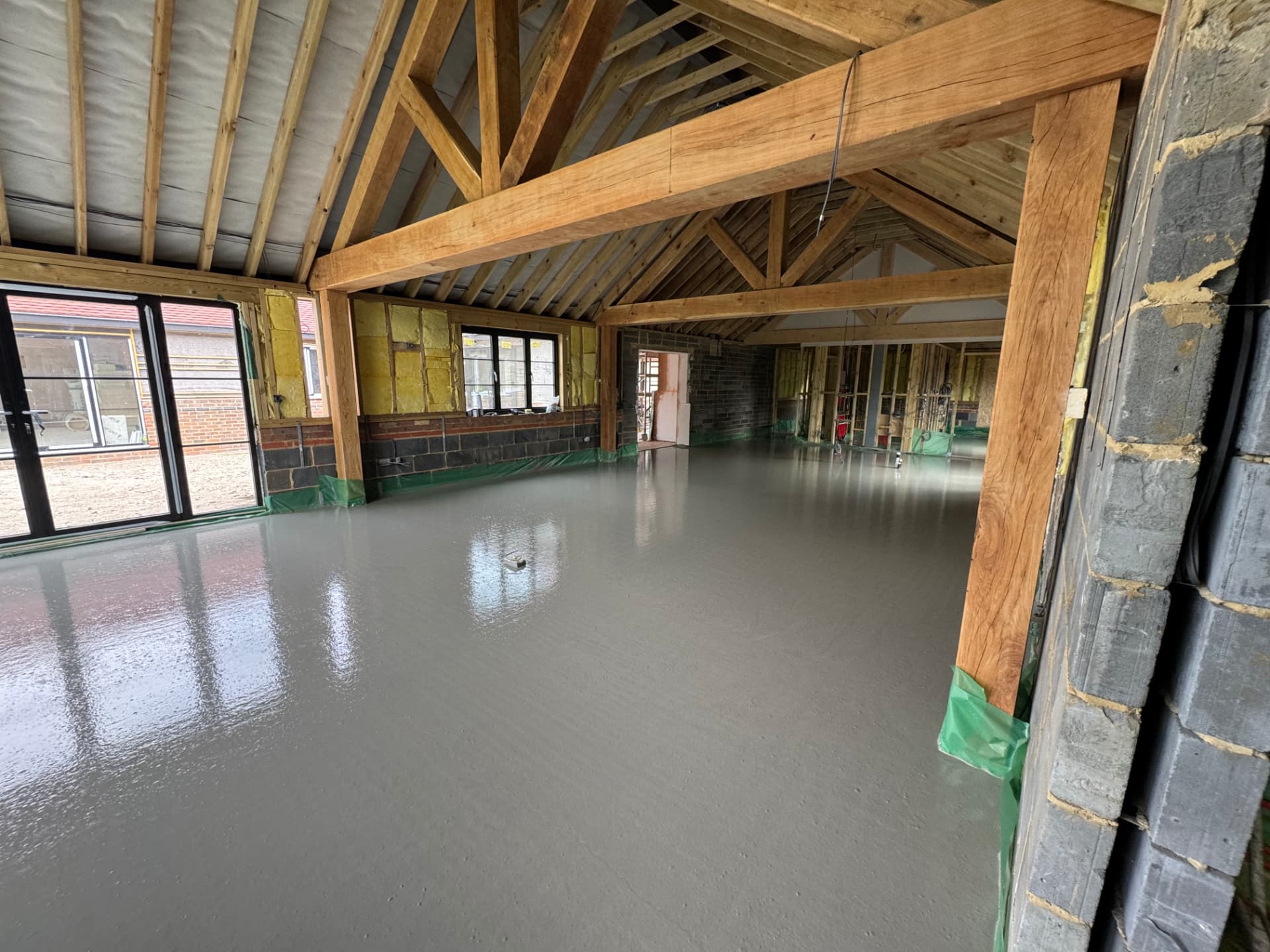 Liquid screed poured across an oak-framed barn conversion floor